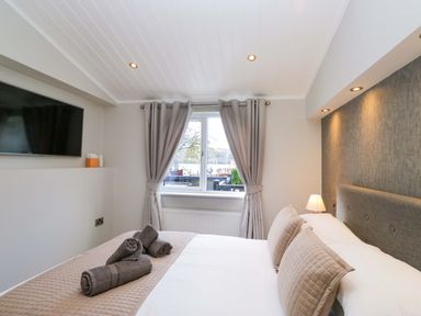 A bedroom with a bed and television at 7 Lake View, Lake View 7, White Cross Bay near Windermere