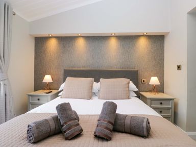 A bedroom with a bed and bedside tables at 7 Lake View, Lake View 7, White Cross Bay near Windermere