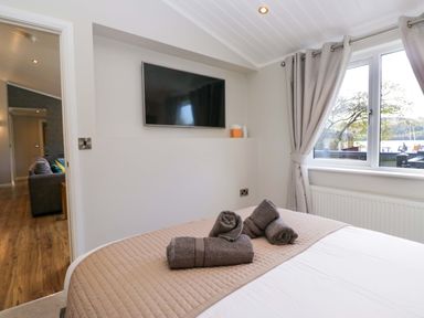 A bedroom with a bed and television at 7 Lake View, Lake View 7, White Cross Bay near Windermere