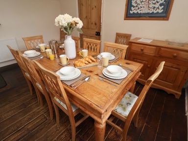 A dining room with a table set for breakfast in Duke Cottage Woodbridge