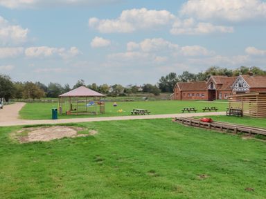 An outdoor area with a gazebo, picnic tables, and grass at Duke Cottage in Woodbridge