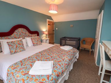 A bedroom with a bed and a crib at Duchess Cottage in Woodbridge