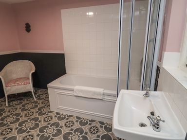 A bathroom with a bathtub and a sink at Duchess Cottage in Woodbridge