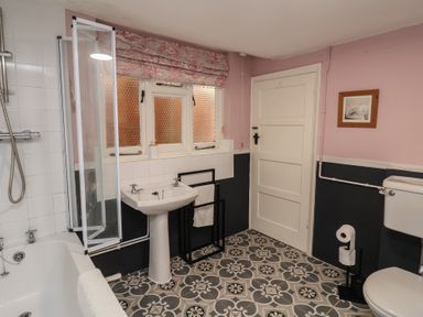 A bathroom with a bathtub, sink, shower, and toilet at Duchess Cottage in Woodbridge