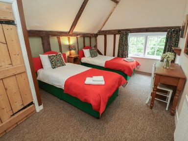 A bedroom with twin beds and a window at Duchess Cottage in Woodbridge