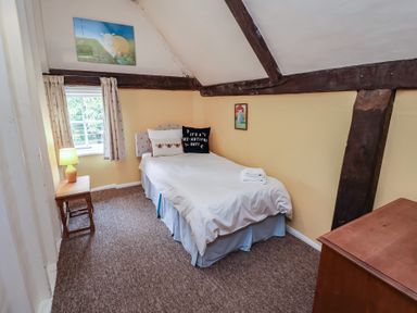 A bedroom with a bed and window at Duchess Cottage in Woodbridge