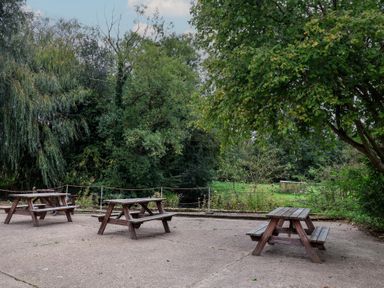 An outdoor area with picnic tables and trees at Duchess Cottage in Woodbridge