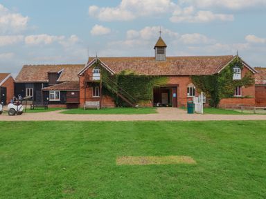 A building with grass in front and a path at Duchess Cottage Woodbridge