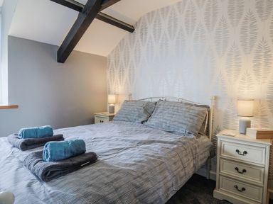 A bedroom with a bed and nightstand at Rushmoor Cottage in Colaton Raleigh