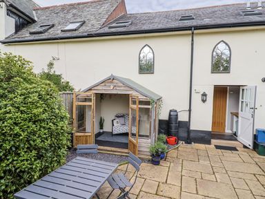 A garden with a shed and outdoor furniture at Rushmoor Cottage in Colaton Raleigh