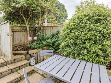 A garden with a table and chairs at Rushmoor Cottage in Colaton Raleigh