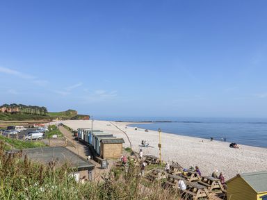 A beach with huts and people relaxing at Rushmoor Cottage Colaton Raleigh