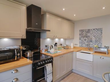A kitchen with a stove and sink at Rushmoor Cottage in Colaton Raleigh