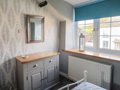 A bedroom with a mirror and chest of drawers at Rushmoor Cottage in Colaton Raleigh