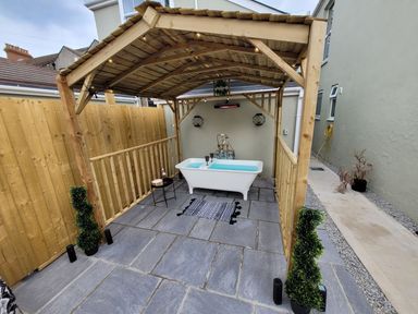 An outdoor area with a bathtub and wooden structure at Klysa in Camborne