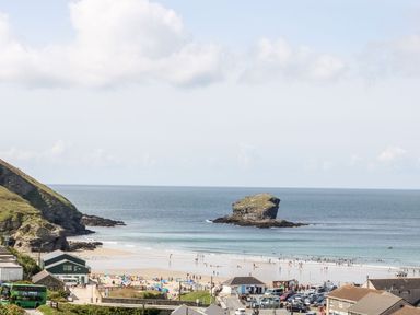 A beach scene with people and a rock formation at Klysa in Camborne