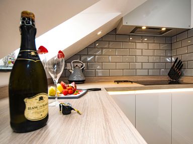 A kitchen with a bottle of champagne and glasses at Thomas Chambers in Camborne