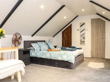 A bedroom with a bed, nightstand, and door at Thomas Chambers in Camborne