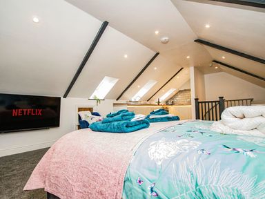A loft bedroom with a bed and television at Thomas Chambers in Camborne