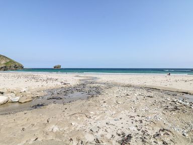 A beach with sand and water at Thomas Chambers in Camborne