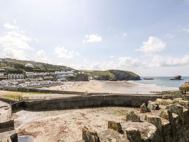 A beach view with houses and cliffs at Thomas Chambers in Camborne