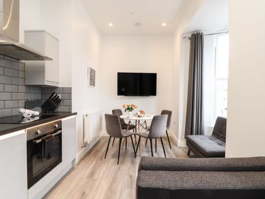 A kitchen with a dining area and a television at Baker Chambers in Camborne