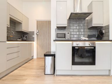 A kitchen with cabinets and appliances at Baker Chambers Camborne