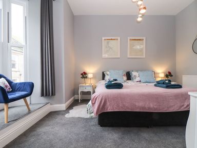 A bedroom with a bed and nightstand at Baker Chambers in Camborne