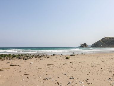 A beach with sand and rocks at Baker Chambers in Camborne