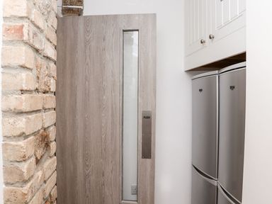 A kitchen with a door and refrigerator at Teylu in Camborne