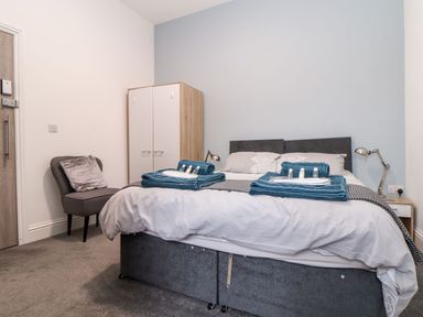 A bedroom with a bed and wardrobe at Teylu in Camborne