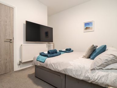 A bedroom with a bed and television at Teylu in Camborne