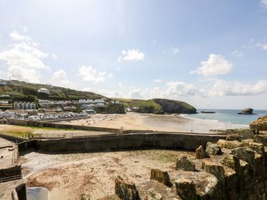 A view of the beach with people and cars at Battell Chambers Camborne