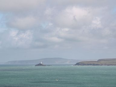 A view of a lighthouse on an island in the ocean at Battell Chambers in Camborne