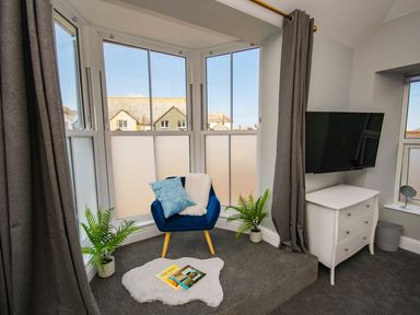 A snug with a chair and television at Daniel Chambers in Camborne
