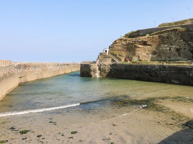 A coastal view with water and rock formations at Daniel Chambers in Camborne