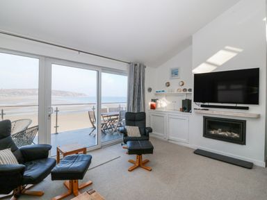 A living room with a view of the beach at Gilfach Goed in Abersoch