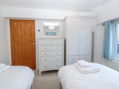 A bedroom with two beds and furniture at Gilfach Goed Abersoch