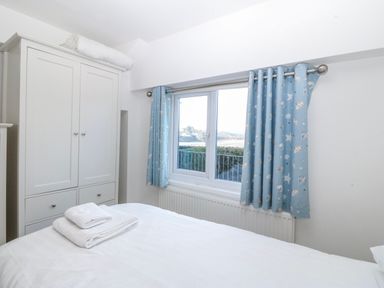 A bedroom with a bed and wardrobe at Gilfach Goed in Abersoch