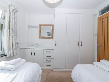 A bedroom with a bed and wardrobe at Gilfach Goed, Abersoch