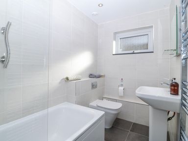A bathroom with a bath, toilet, and sink at Gilfach Goed in Abersoch