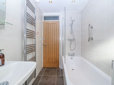 A bathroom with a bathtub and shower fixtures at Gilfach Goed in Abersoch