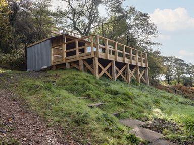 A deck with steps and a shed on a hillside at Gwyn Studio in Aberdare