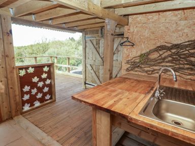 An outdoor kitchen with a sink and wooden countertop at Gwyn Studio in Aberdare