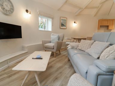 A living room with a television and seating area at Round Barn in Ilfracombe