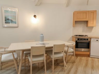 A dining room with a table and chairs at Round Barn in Ilfracombe