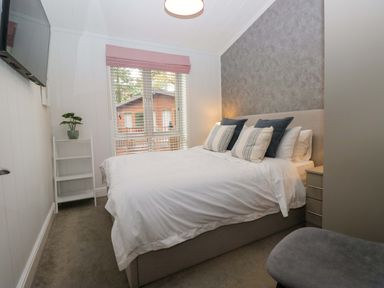 A bedroom with a bed and a television at 5 Waterside Wood Troutbeck Bridge