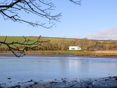 A house with solar panels by the water at Bryncyn in Newport, Pembrokeshire