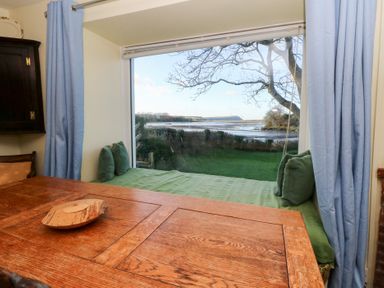 A dining room with a view of the landscape at Bryncyn in Newport, Pembrokeshire