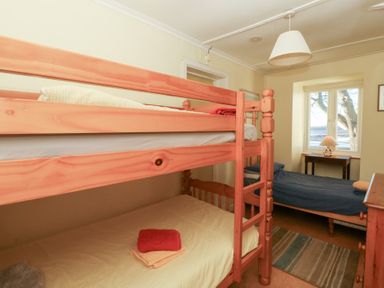 A bedroom with bunk bed and single bed at Bryncyn in Newport, Pembrokeshire